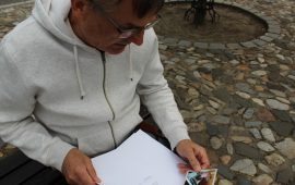 Wiesław Świder ze łzami w oczach wertuje dokumenty fundacji spoglądając na zdjęcie małego Szymonka